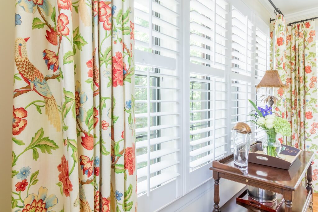 Draperies layered with plantation shutters