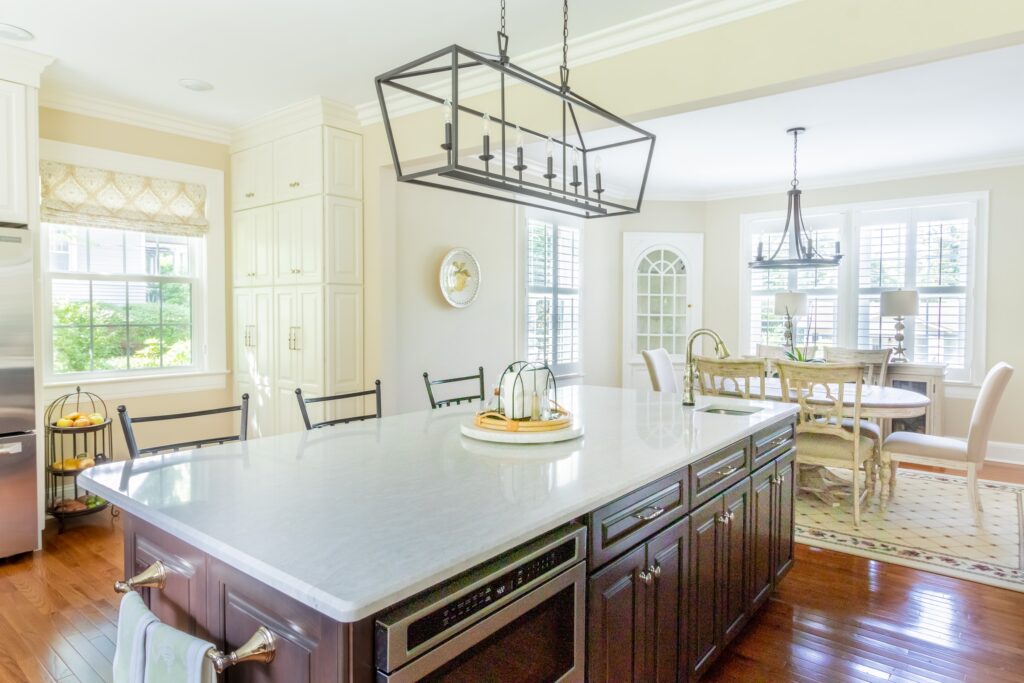 Traditional kitchen with Roman shade by the refrigerator and plantation shutters in the dining area