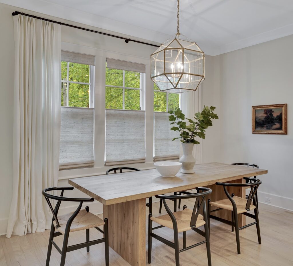  Minimal dining area with floor-length drapery panels and top-up/bottom-down shades on the windows