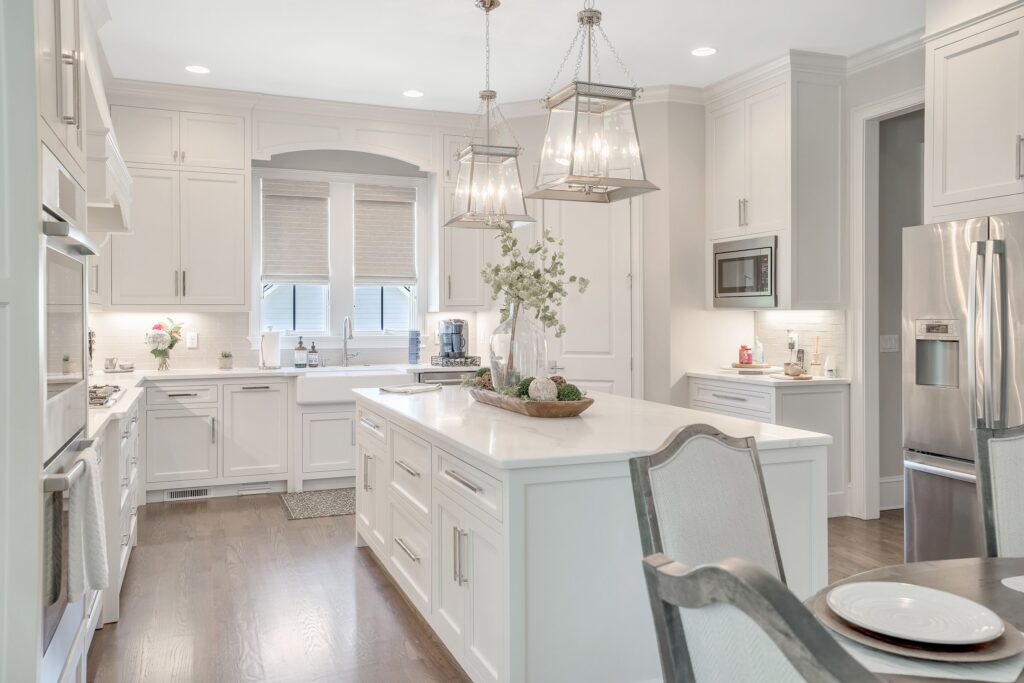 all white kitchen with Roman shades above the sink