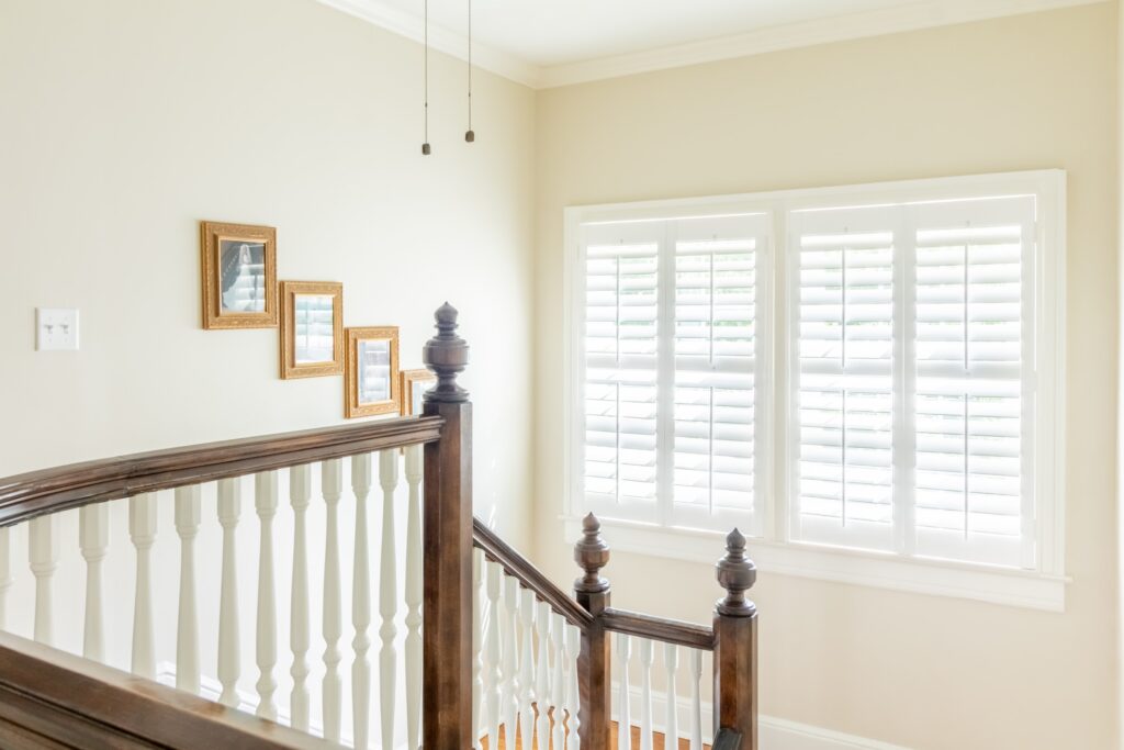 Stairwell in front of window with plantation shutters