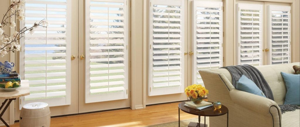 Interior shutters covering row of patio doors in home living room