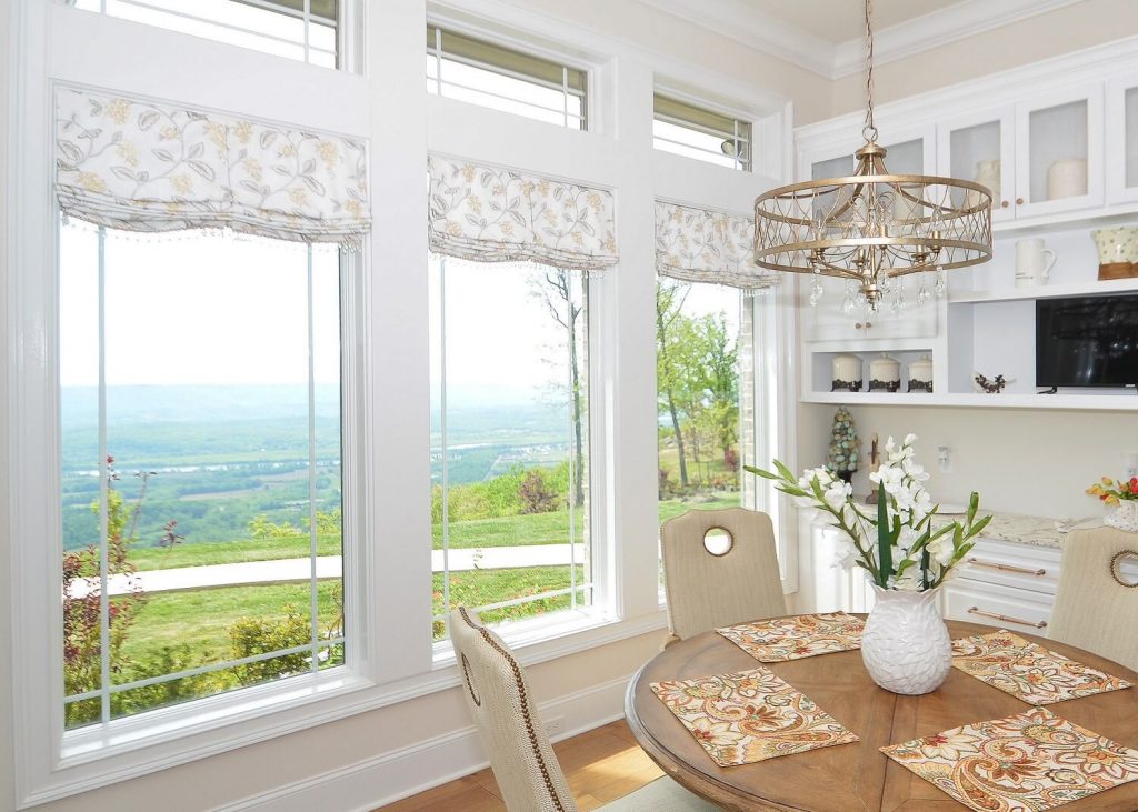 breakfast table in front of windows with relaxed roman shades and a mountain view