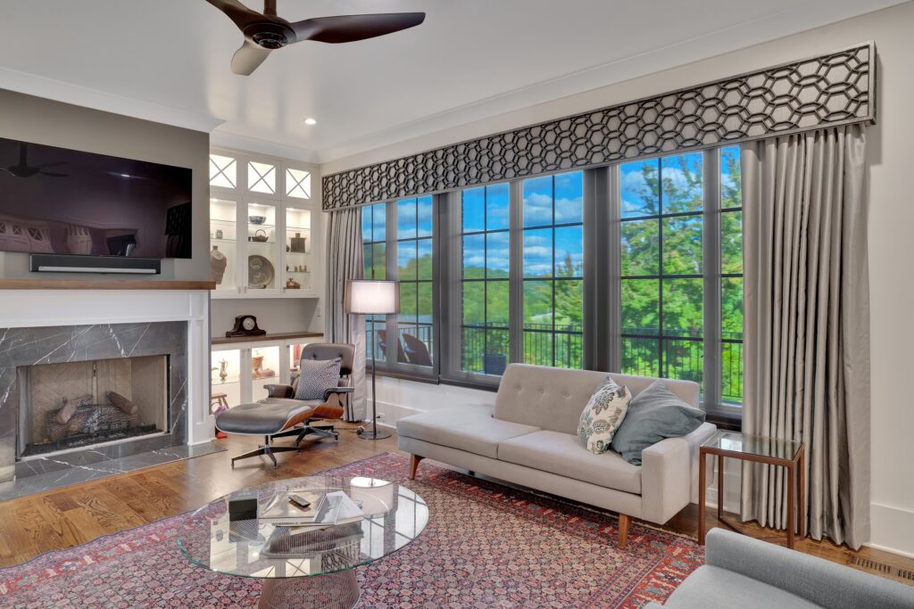 Chattanooga, TN living room with layered window treatments, including drapery panels and a straight cornice for the motorized shades to hide behind when open