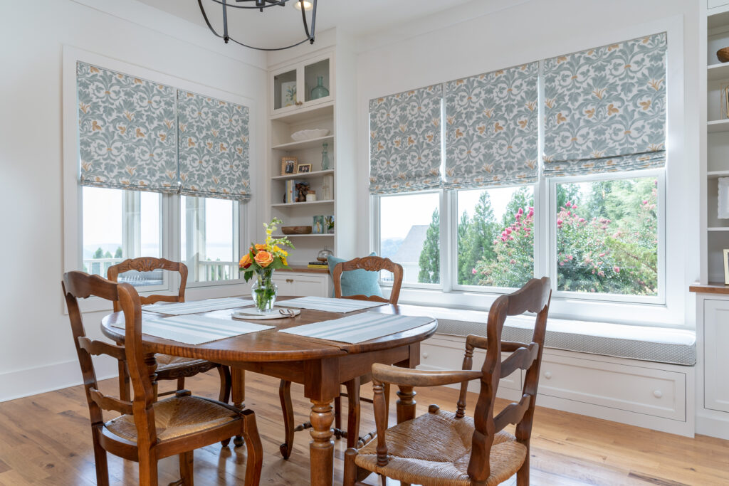 round wood kitchen table in white kitchen in chattanooga with window seat and custom roman shades in aqua and gold