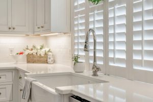 Interior shutters covering kitchen window next to sink