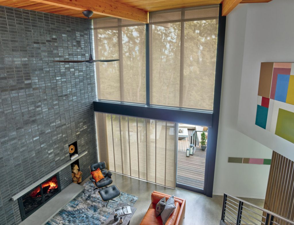 living room with roller shades and very high windows with a fireplace