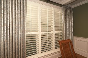 Interior shutters and custom drapery treatments for set of house windows