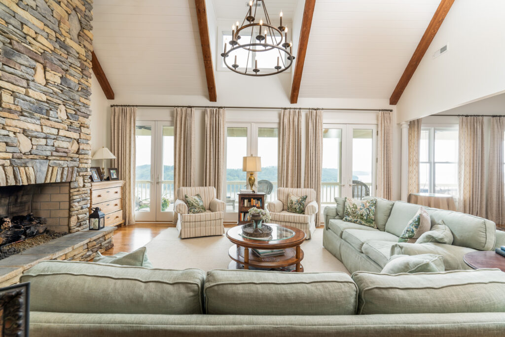 traditional living room in chattanooga with stone fireplace, custom drapery panels, and custom pillows in blues, greens, and tans